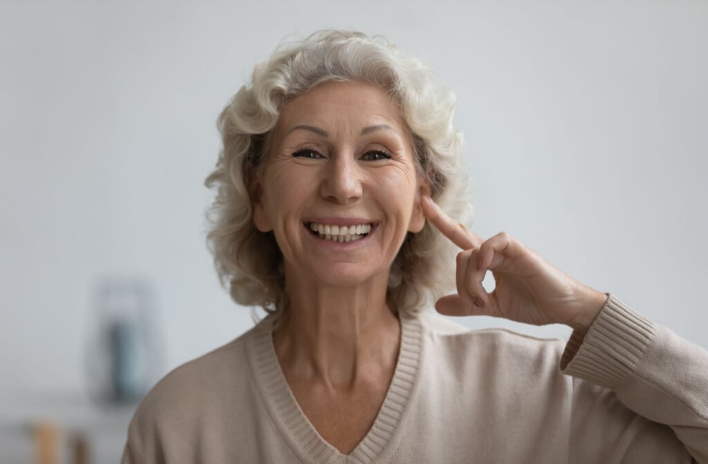 A smiling senior points to their brain, confident in taking charge of their health after being diagnosed with dementia